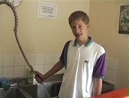 Ryan gets hot water in the kitchen at Street youth hostel